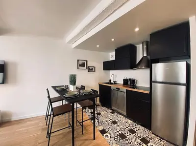 a kitchen with a table and a stainless steel refrigerator at Appartement Centre ville, Cannes le Suquet in Cannes
