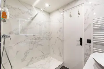 a white bathroom with a shower and a sink at Appartemet a Cannes/Plage/Centre in Cannes