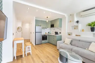 a living room with a couch and a kitchen at Appartemet a Cannes/Plage/Centre in Cannes