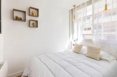 a white bed in a white room with a window at Appartemet a Cannes/Plage/Centre in Cannes