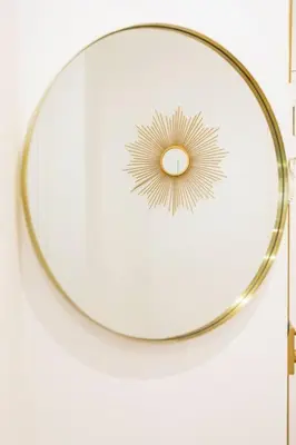 a round mirror with a gold rim on a wall at Appartemet a Cannes/Plage/Centre in Cannes