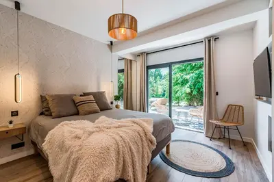 a bedroom with a bed and a sliding glass door at Villa Quartier Oxford garden & pool in Cannes AC in Cannes