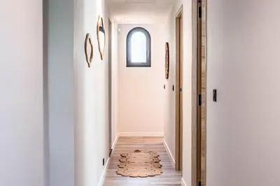 a hallway with white walls and a rug on the floor at Villa Quartier Oxford garden & pool in Cannes AC in Cannes