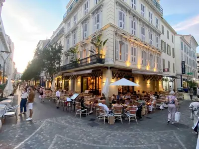 a group of people sitting at tables outside a building at Villa Quartier Oxford garden & pool in Cannes AC in Cannes