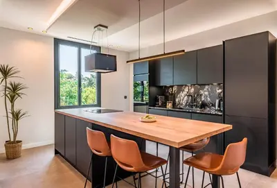 a kitchen with a wooden table and chairs at Villa Quartier Oxford garden & pool in Cannes AC in Cannes