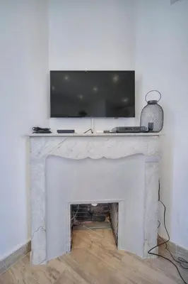 a fireplace with a television on top of it at IMMOGROOM-Suquet-AC-WIFI-close to the beaches in Cannes