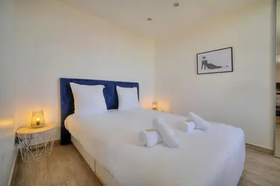 a bedroom with a large white bed with two pillows at IMMOGROOM-Suquet-AC-WIFI-close to the beaches in Cannes