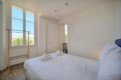 a bedroom with a white bed and a window at IMMOGROOM-Suquet-AC-WIFI-close to the beaches in Cannes