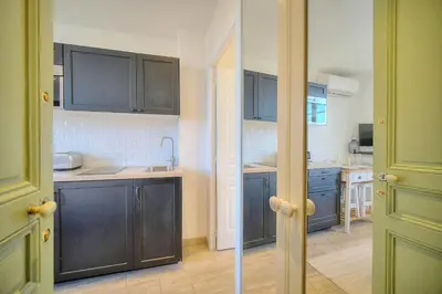 a kitchen with black cabinets and a sink and counters at IMMOGROOM-Suquet-AC-WIFI-close to the beaches in Cannes