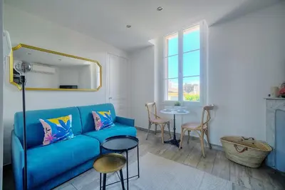 a living room with a blue couch and a table at IMMOGROOM-Suquet-AC-WIFI-close to the beaches in Cannes