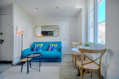 a living room with a blue couch and a table at IMMOGROOM-Suquet-AC-WIFI-close to the beaches in Cannes