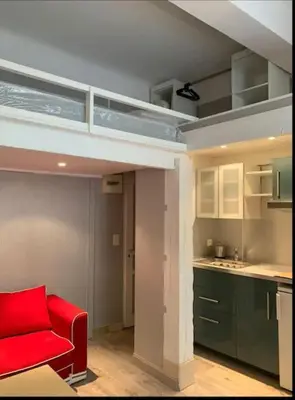 a living room with a red chair and a kitchen at Grand studio centre Cannes in Cannes