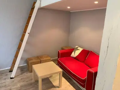 a living room with a red couch and a table at Grand studio centre Cannes in Cannes