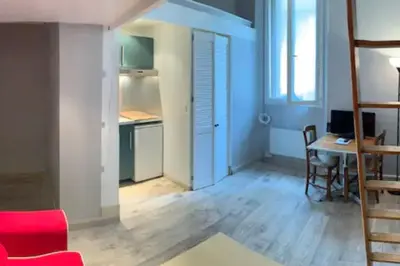 a living room with a red couch and a table at Grand studio centre Cannes in Cannes