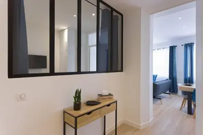 a living room with a table and a mirror on the wall at Rue De Bone by Halldis in Cannes