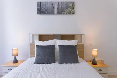 a bedroom with a white bed with two lamps at Rue De Bone by Halldis in Cannes