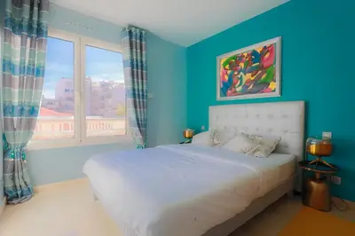 a blue bedroom with a bed and a window at CROISETTE AZUR ONE BEDROOM APARTMENT WITH TERRACE in Cannes