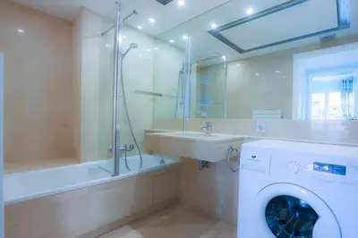 a bathroom with a washing machine and a sink at CROISETTE AZUR ONE BEDROOM APARTMENT WITH TERRACE in Cannes