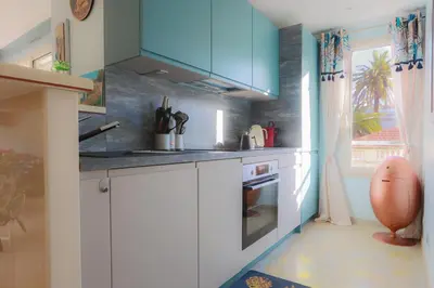 a kitchen with white cabinets and a blue at CROISETTE AZUR ONE BEDROOM APARTMENT WITH TERRACE in Cannes