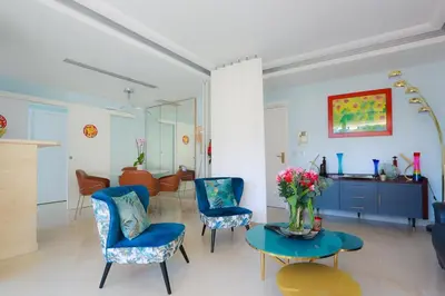 a living room with chairs and a table with a vase of flowers at CROISETTE AZUR ONE BEDROOM APARTMENT WITH TERRACE in Cannes